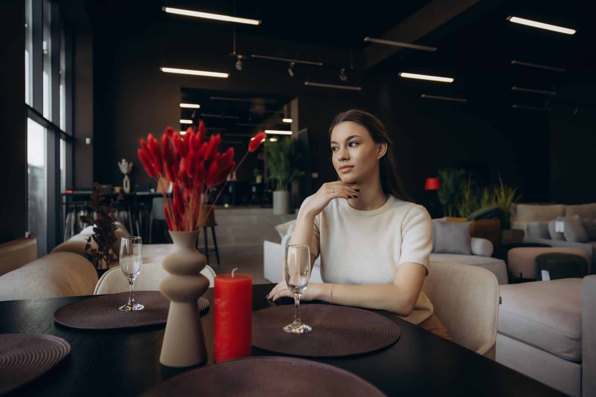 Escort Mannheim: Junge Frau am Tisch in moderner Lounge